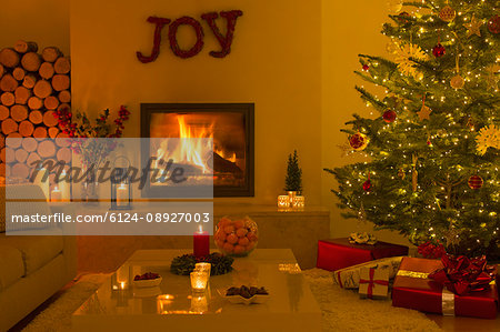 Ambient fireplace and candles in living room with Christmas tree