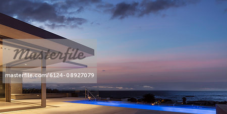 Tranquil dusk sky over illuminated home showcase exterior patio with lap swimming pool Tranquil dusk sky over illuminated home showcase exterior patio with lap swimming pool