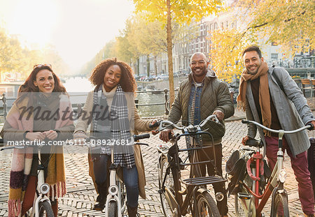 Portrait smiling friends bike riding on urban autumn street, Amsterdam
