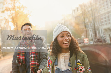 Laughing young couple walking on urban autumn street, Amsterdam