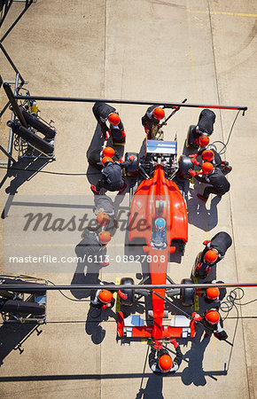 Overhead pit crew working on formula one race car in pit lane