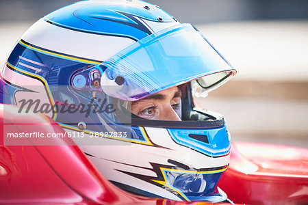 Close up formula one race car driver in helmet looking away