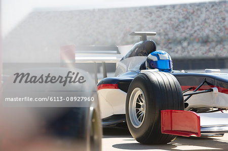 Formula one race car and driver in pit lane