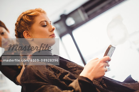 Beautiful woman using mobile phone in saloon