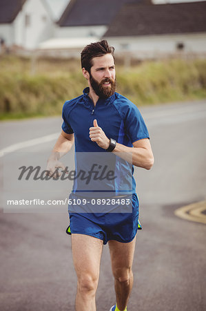 Handsome athlete running on the road