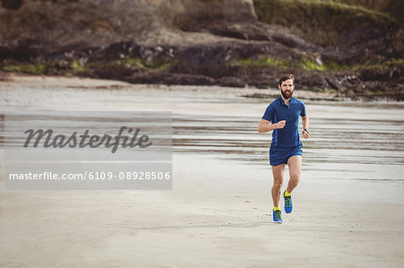 Handsome athlete running on the road