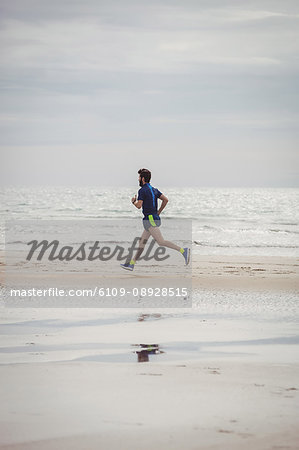 Athlete running along the beach on a sunny day