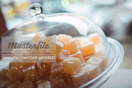 Close-up of turkish sweets in a glass jar arranged on shelf in shop