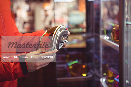 Close-up of man selecting ski goggles in a shop