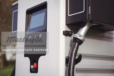 Close-up of car charger at electric vehicle charging station