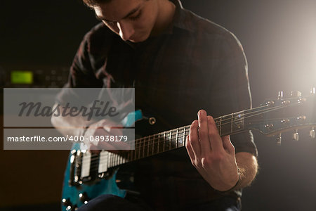 Close Up Of Man Using Tapping Technique On Electric Guitar