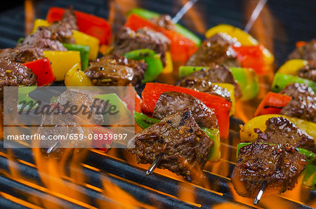 Beef skewers with peppers on a flaming barbecue