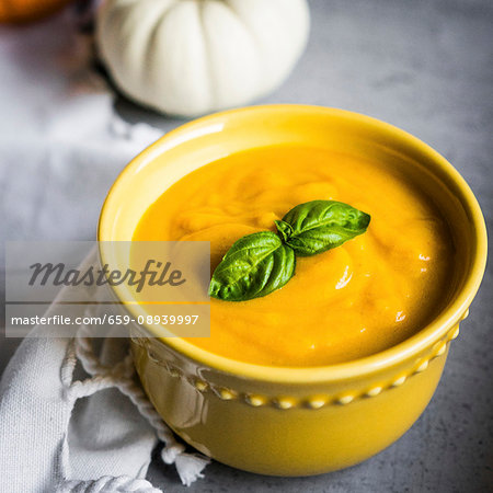 Cream of pumpkin soup garnished with basil