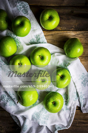 Bright green apples on wooden surface