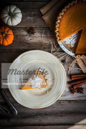 Pumpkin pie on a rustic wooden surface (seen from above)