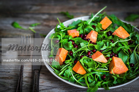 Fresh rocket and spinach salad with pumpkin and pomegranate seeds