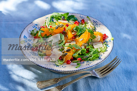 Rocket salad with oranges, pomegranate seeds, Parmesan cheese and pumpkin seeds