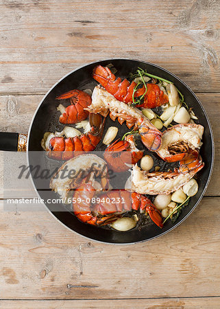 Fried lobster tails with garlic in a pan