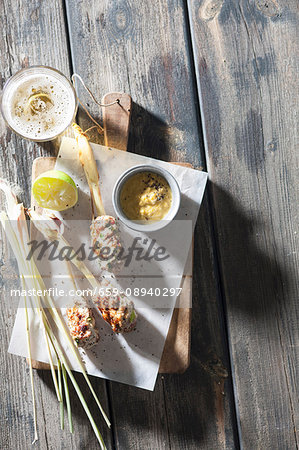 Minced meat and lemongrass skewers with a yellow pepper dip (seen from above)