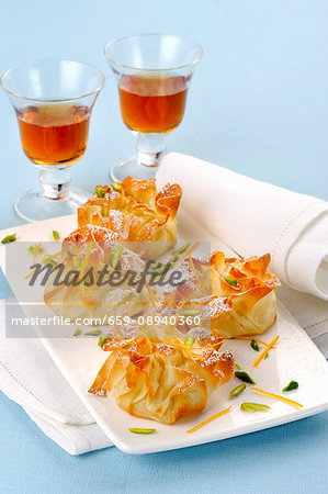 Sweet filo pastry sacks with pistachios and icing sugar served with dessert wine