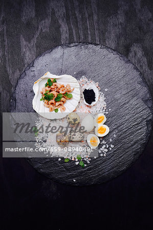 Quail's eggs, shrimps and caviar in a scallop shell