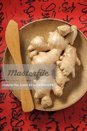 Fresh ginger roots on a wooden plate