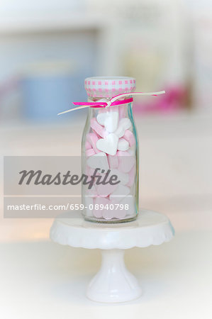 Pink and white peppermint hearts in a small glass bottle