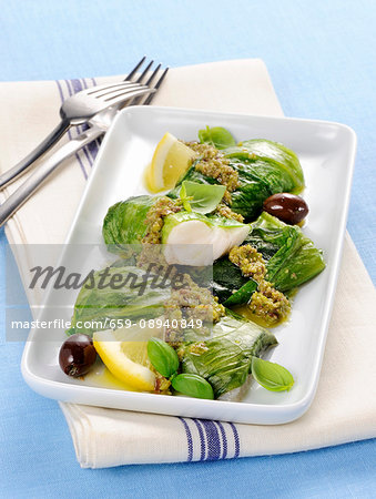 Hake and lettuce rolls with a green olive sauce and lemons