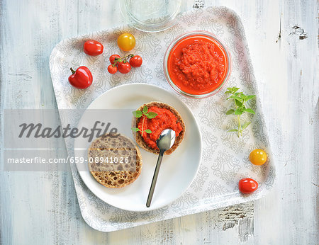 Ajvar in a jar and on half a bread roll