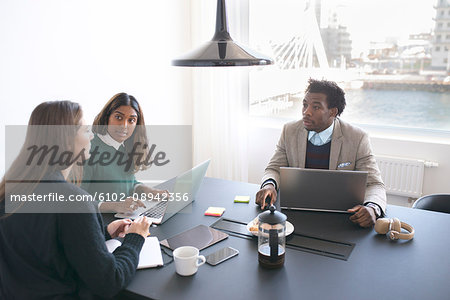 Man and women using laptops in office