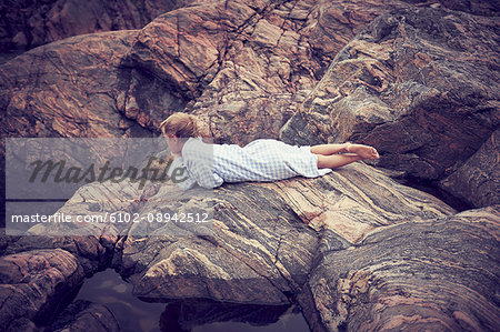 Boy lying on rocks
