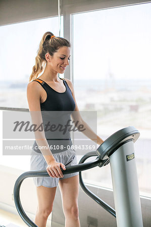 Woman running on treadmill in fitness center