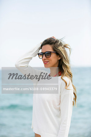 Pretty blonde woman with sunglasses at the beach