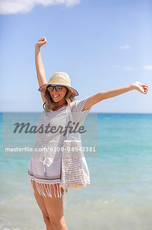 Happy blonde woman arriving at the beach