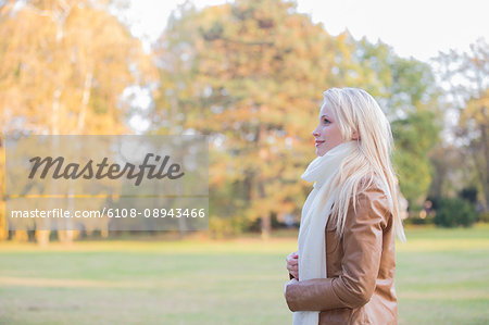 Side view of a pretty blonde woman in Park in Autumn