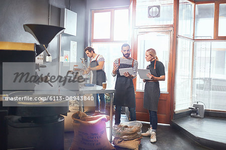 Coffee roasters with clipboard and digital tablet meeting