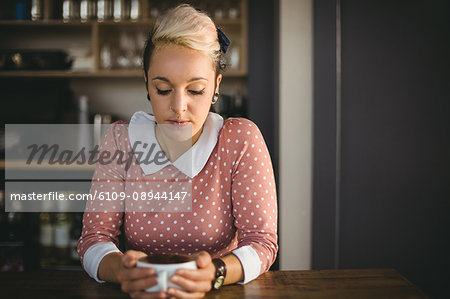 Woman holding coffee cup in café