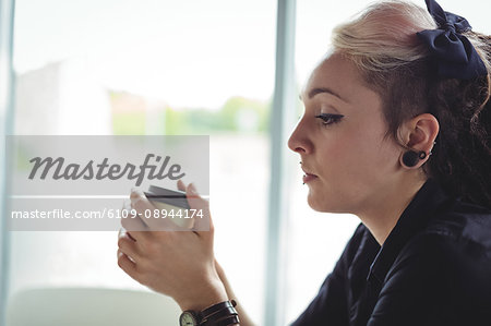 Woman holding disposable coffee cup in café