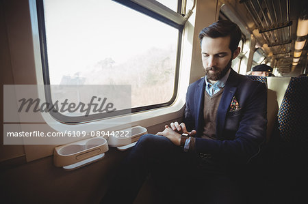 Businessman checking using smartwatch while travelling in train