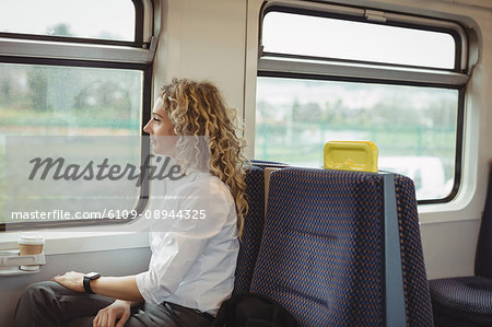 Thoughtful woman looking out through train window