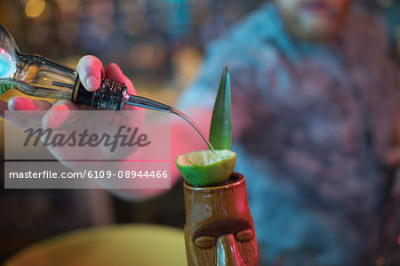 Bartender preparing a drink at counter in bar