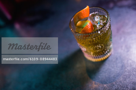 Close up of orange cocktail in glass at counter in bar