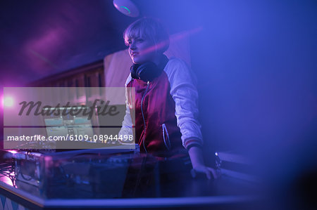 Pretty female dj playing music in bar Pretty female dj playing music in bar