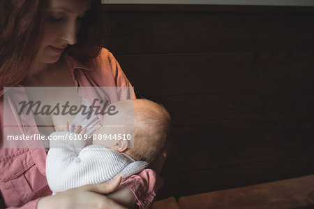 Mother breastfeeding her baby in café