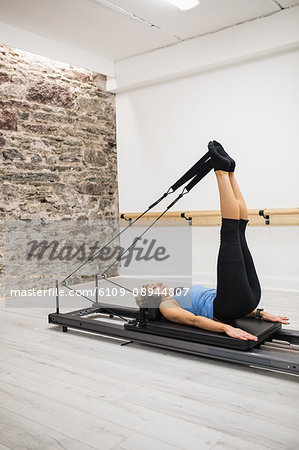 Woman exercising on reformer in gym