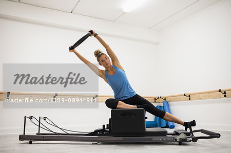 Woman exercising with pilates ring in gym