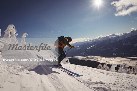 Skier skiing in snowy alps during winter