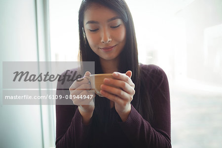 Beautiful woman having cup of coffee at café
