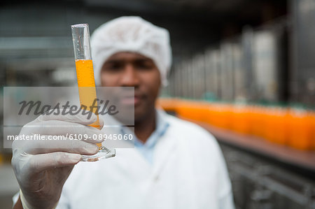Close up of male worker checking juice in factory