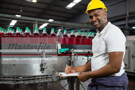 Portrait of young male worker noting in factory